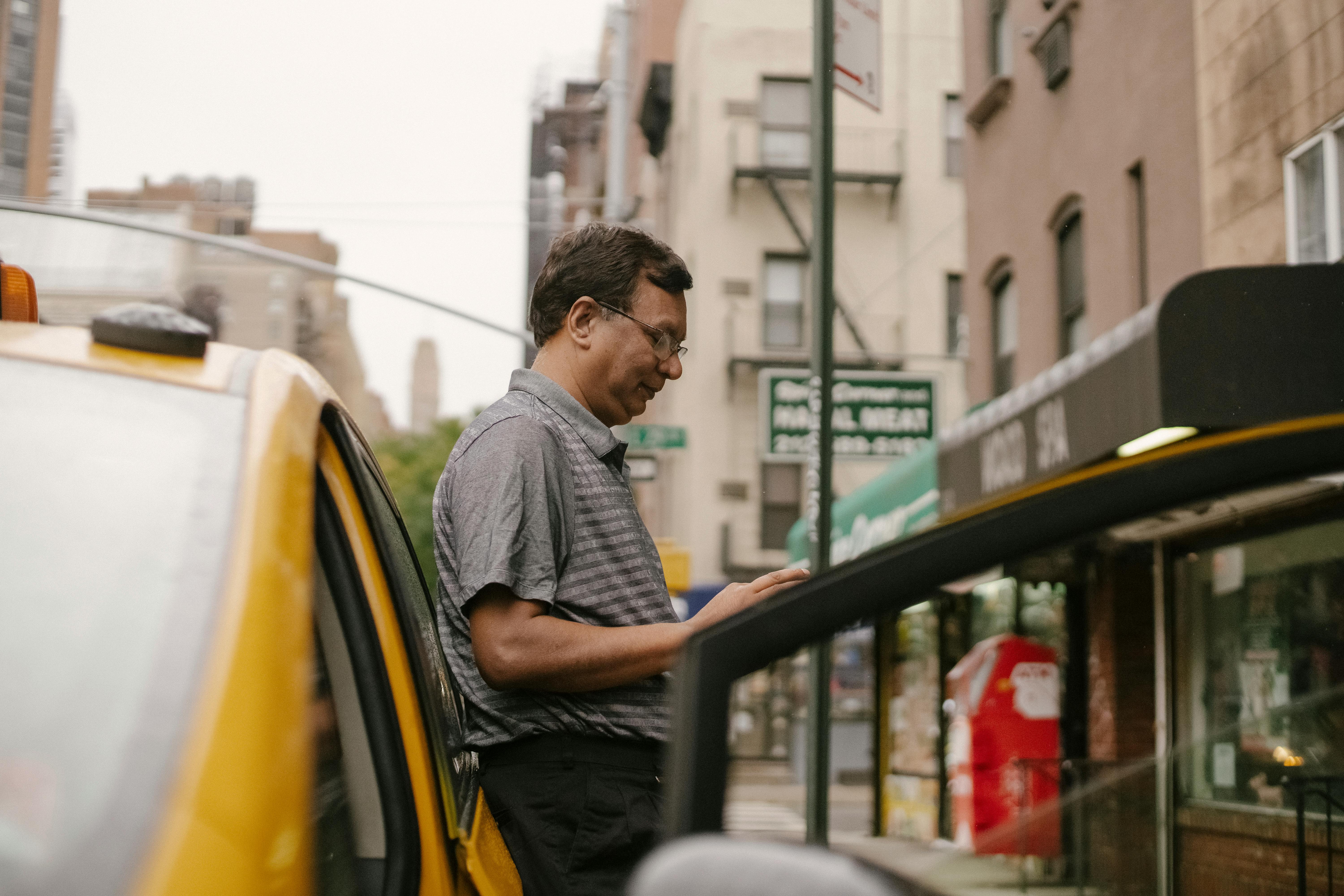 OneFare driver standing beside cab